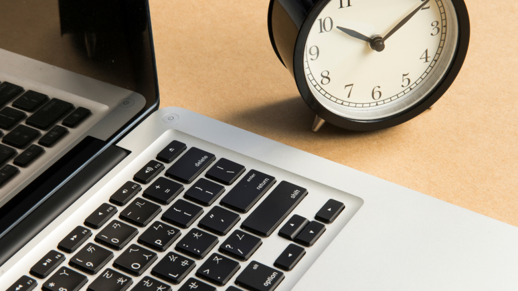 Office desk with clock and laptop