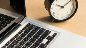 Office desk with clock and laptop