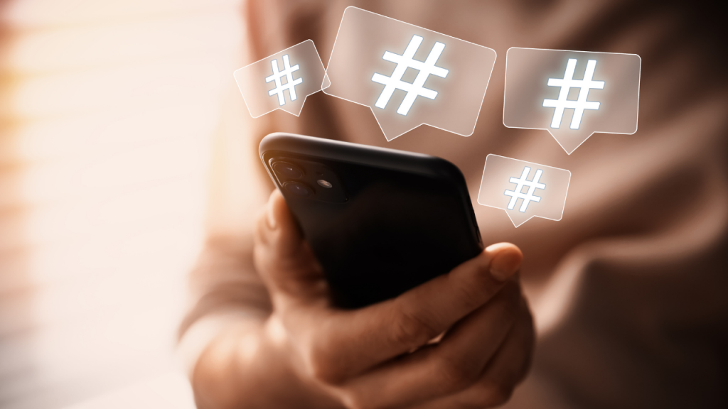 Man Using Modern Smartphone, Closeup. Hashtag Symbols over Device