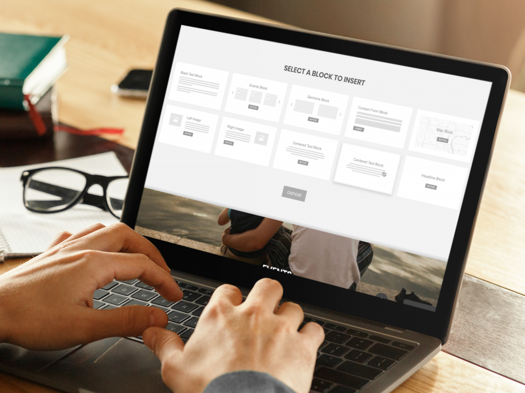 man working on his laptop with his glasses over his desk