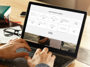 man working on his laptop with his glasses over his desk