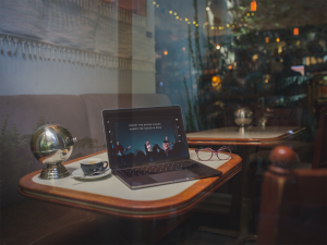 macbook through the window with a christmas tree behind it