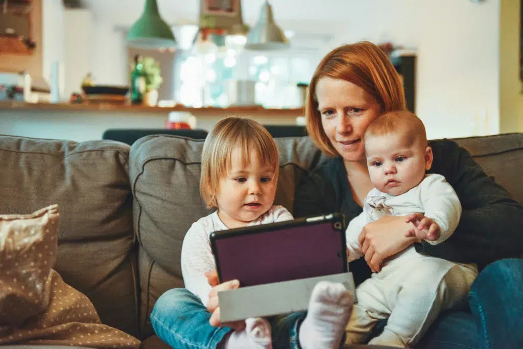 Mom with her two babies looking at a tablet