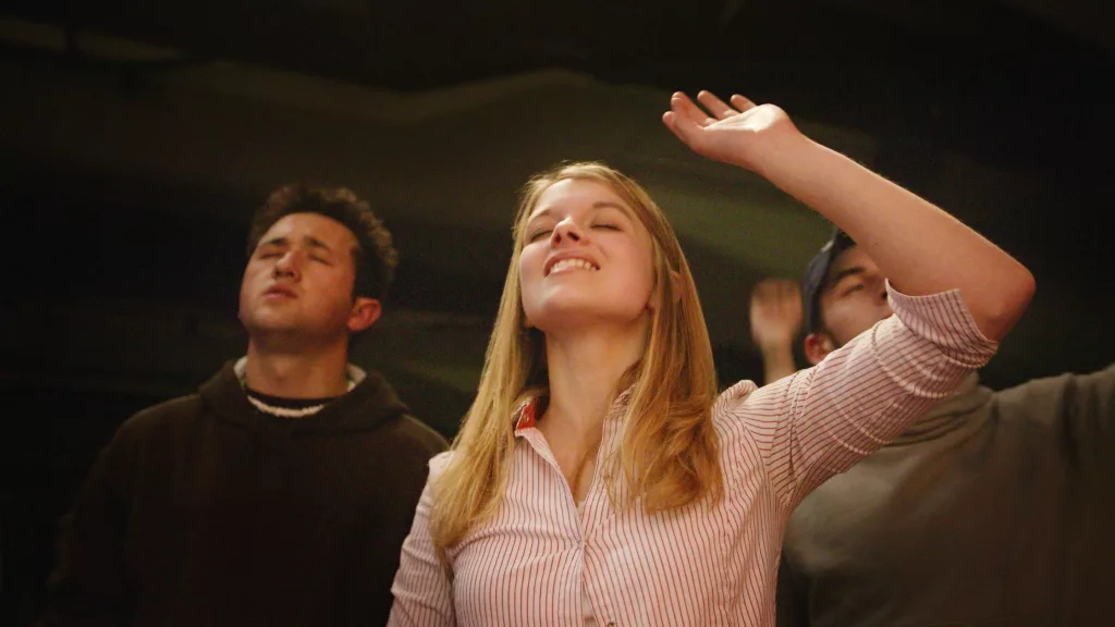 girl raising hands to worship