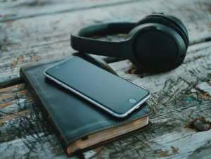 cellphone on top of the bible with headphone beside