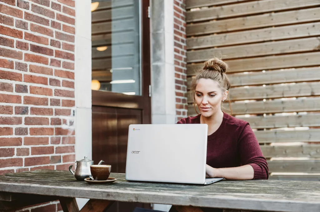 woman on laptop outside the house