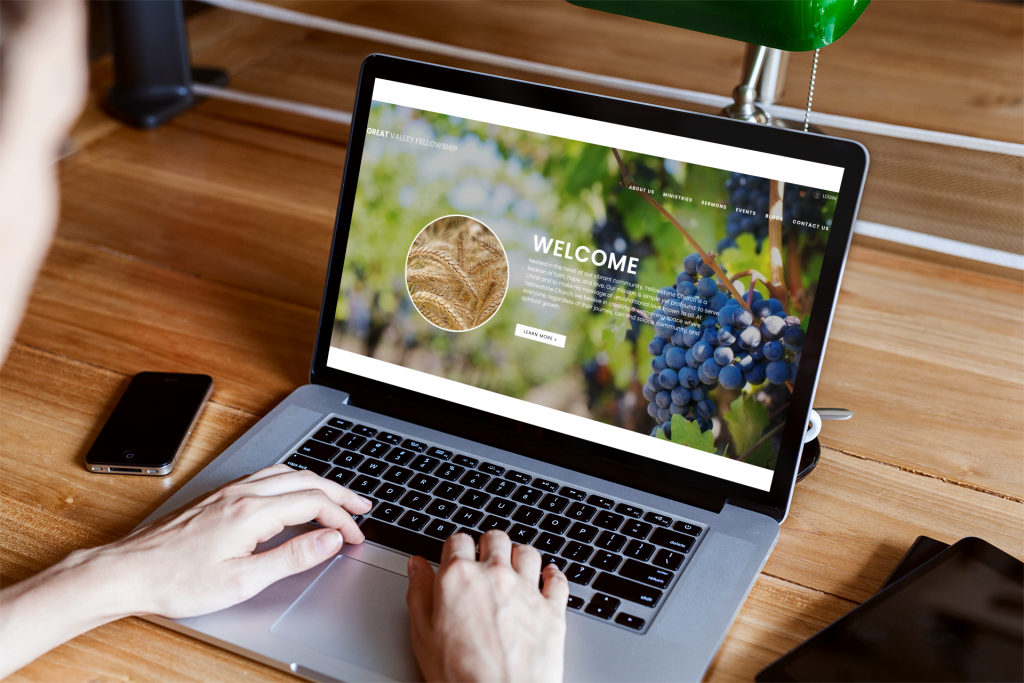person using macbook on a wooden table