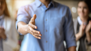 person reaching out hand for a handshake