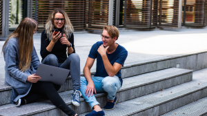 Three Persons Sitting on the Stairs Talking With Each Other