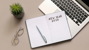 Notebook with Text NEW YEAR 2026 and Laptop on Grey Background